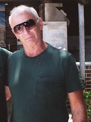 Neddy Smith wearing a brown shades and green t-shirt