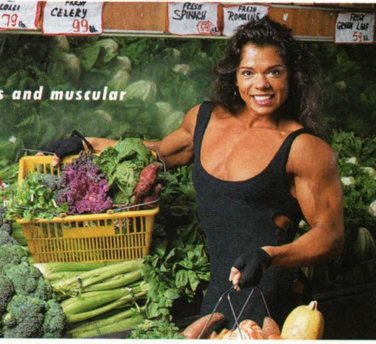 Negrita Jayde smiling and holding two baskets full of vegetables while wearing a black sleeve