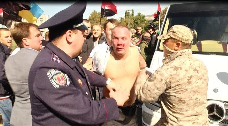 Nestor Shufrych was beaten by a mob in Odesa, Ukraine while the local police are helping him. Nestor is topless with blood on his face.