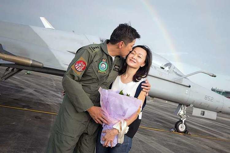 Ng Chee Meng kissing his wife Datin Michelle Lim Bee Leng while wearing an air force uniform
