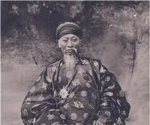 Nguyễn Đình Chiểu with beard while wearing Ao Dai and headband