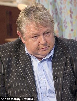 Nick Ferrari wearing a blue shirt and a black striped coat