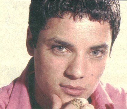 Nick Kamen wearing pinks long sleeves while hand on his chin