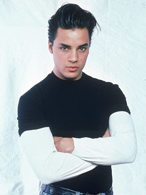 Nick Kamen in his black and white long sleeves while his arms crossed