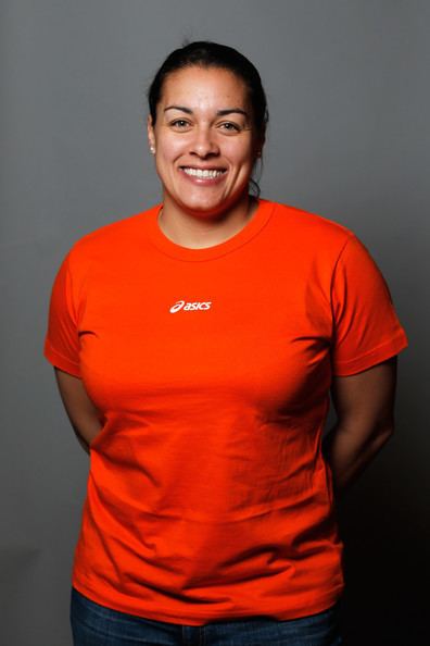 Nicola Minichiello smiling while wearing a bright orange t-shirt with the Asics logo on the front