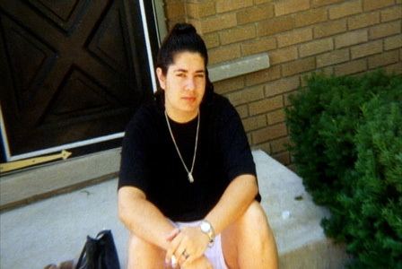 Nicole Abusharif sitting on the floor while wearing a black t-shirt and white shorts