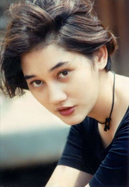 Nike Ardilla in short hair wearing a black necklace and shirt