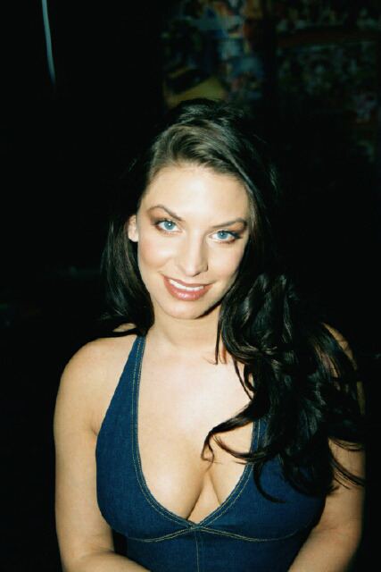 Nikki Dial smiling and wearing blue sleeveless clothing and having long, black hair.