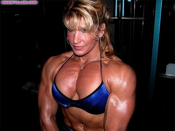 Nikki Fuller showing her muscular body while wearing a blue bikini, earrings, and necklace