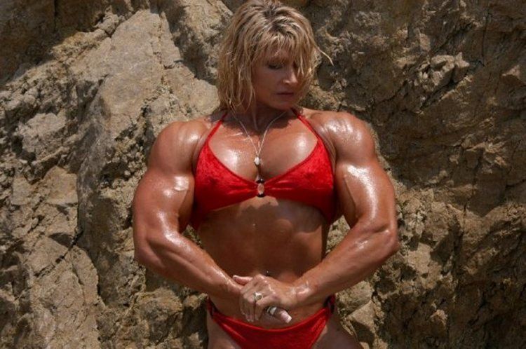 Nikki Fuller showing her muscular body while wearing a red bikini and necklace