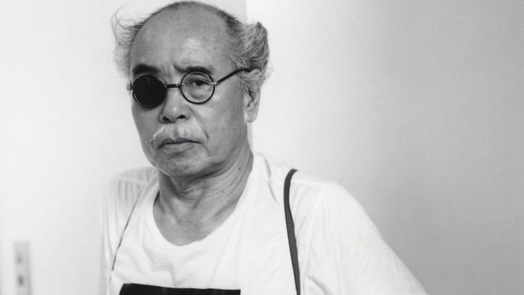 Nobuyoshi Araki wearing eyeglasses and a white shirt.