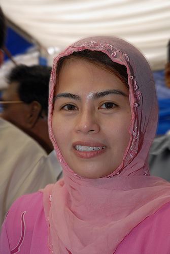 Noraini Ahmad smiling while wearing a pink hijab and pink blouse