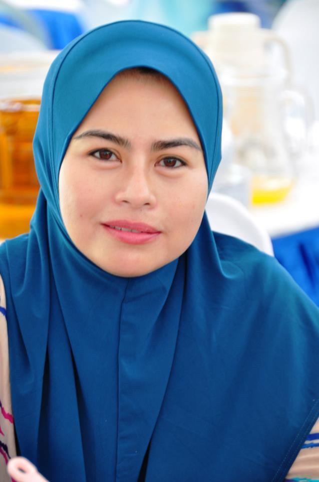 Noraini Ahmad with a tight-lipped smile while wearing a blue hijab