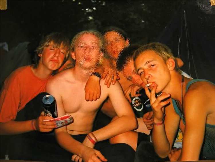Oliver Loftéen camping with his friends and smoking a cigarette while wearing a sleeveless shirt.