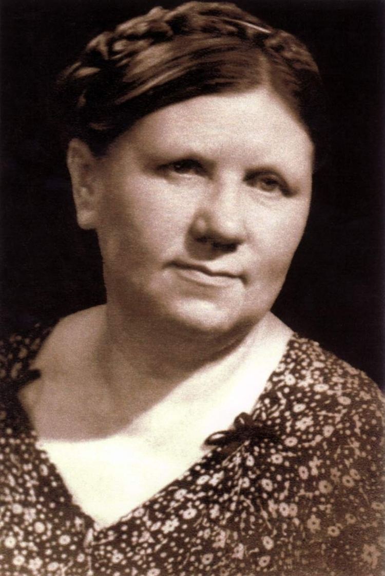 Ona Šimaitė in the black background wearing a floral dress