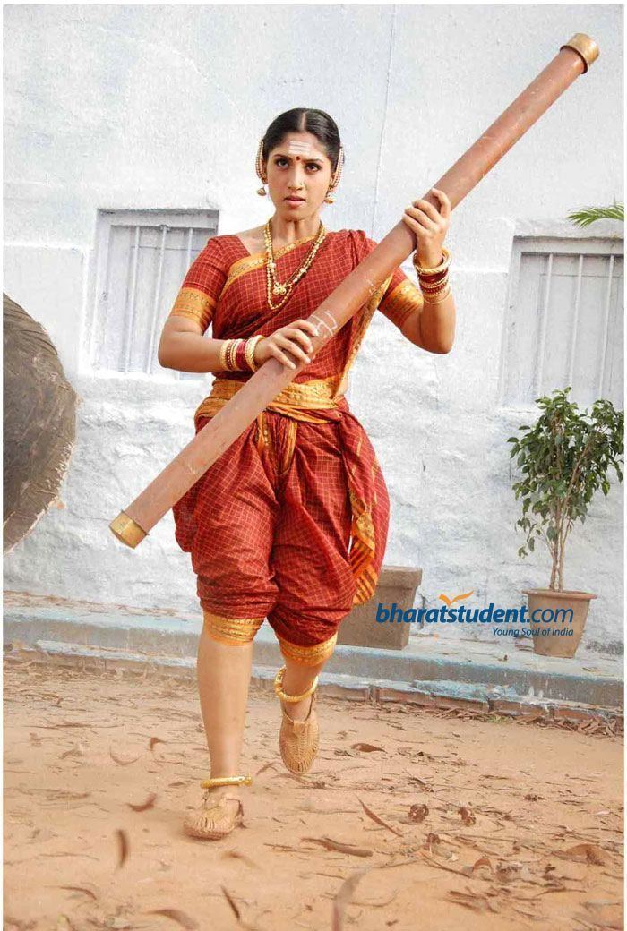Onake Obavva, was a Hindu warrior who fought with a long pestle, wearing an orange and yellow dress and wearing gold accessories.