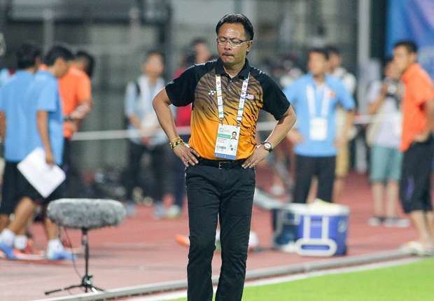 Ong Kim Swee wearing a black and orange t-shirt, eyeglasses, id, and black pants