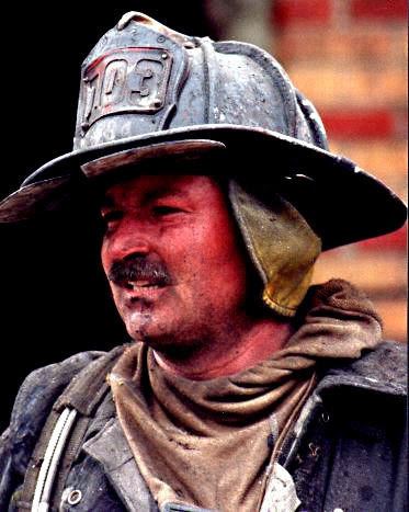 Orio Palmer with dirt on his face while wearing bunker gear and a helmet