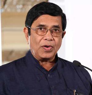 Oscar Fernandes giving a speech while wearing blue long sleeves and eyeglasses