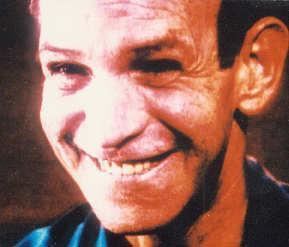 Ottis Toole smiling and wearing a black and blue shirt.