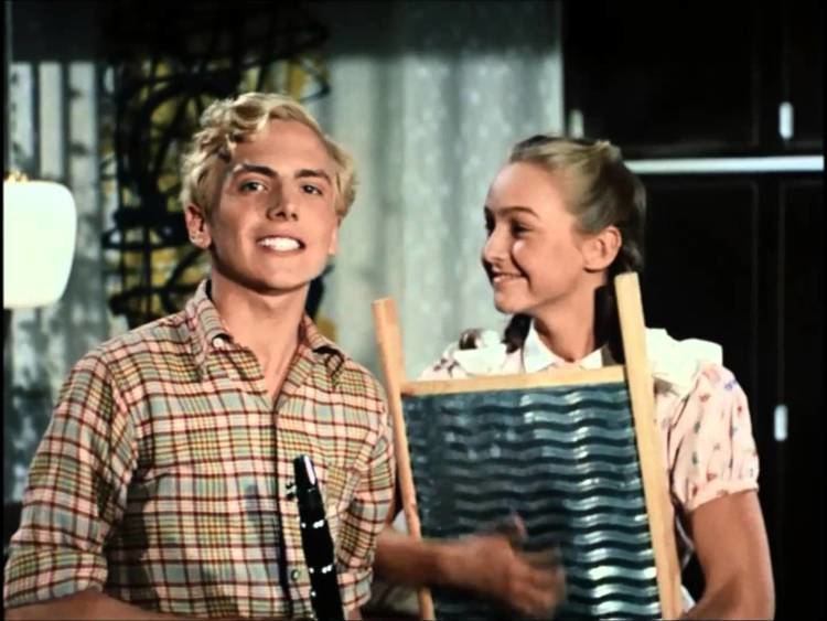 Otto Møller Jensen smiling while wearing checkered long sleeves with Rudi Hansen in a movie scene from Far til fire og ulveungerne (1958 film)