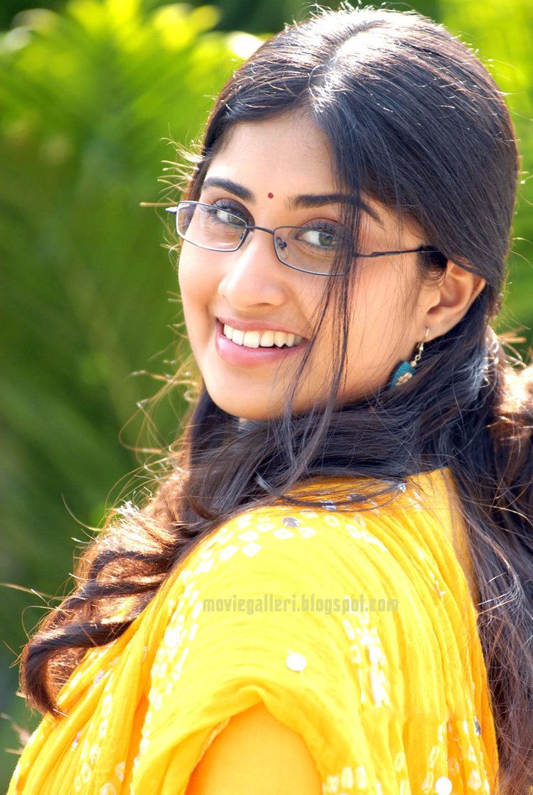 Oye! (film) Shamili smiles while wearing a yellow shirt and blue earrings