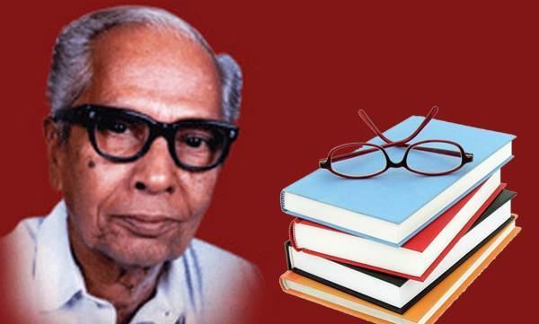 P N Panicker (left) smiling with his gray hair in a red background, and on his left was a pile of books with an eyeglass on top of it, he is wearing black eyeglass and a white polo