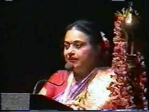 Padmini giving a speech while wearing a red and violet dress