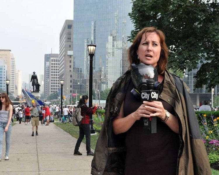 Pam Seatle at work as news presenter while wearing brown and black jacket and black dress