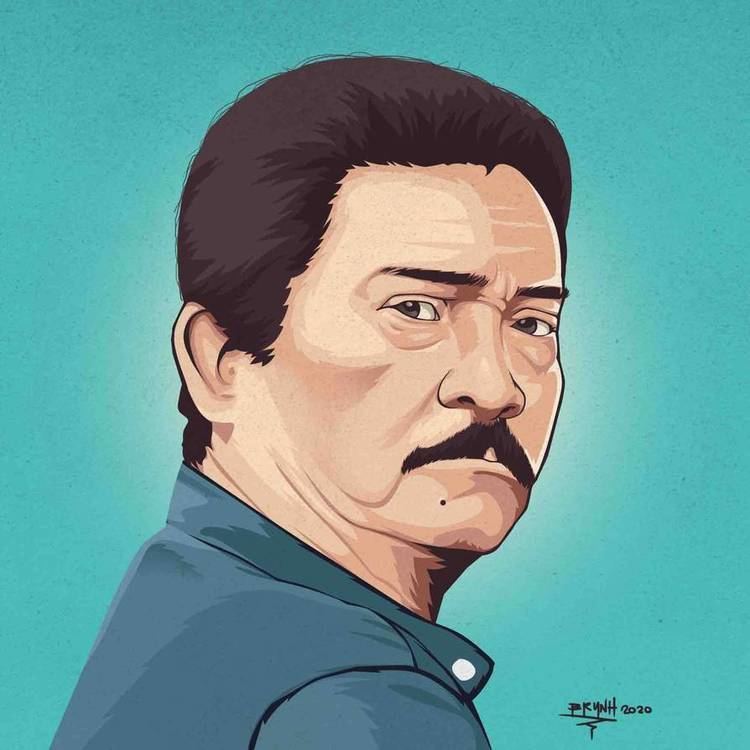A portrait of Paquito Diaz with mustache while wearing a blue polo shirt