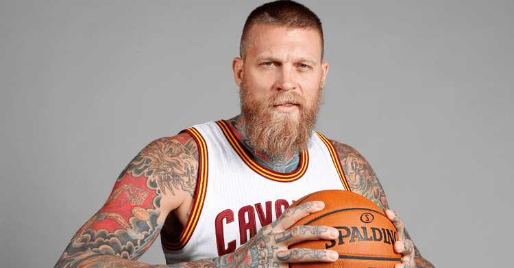 Chris Andersen holding a ball while wearing a basketball jersey