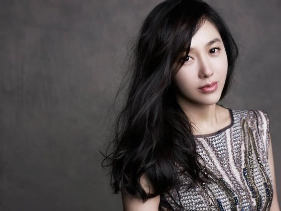 Park Joo-mi with a serious face and long curly black hair while wearing a sleeveless top.