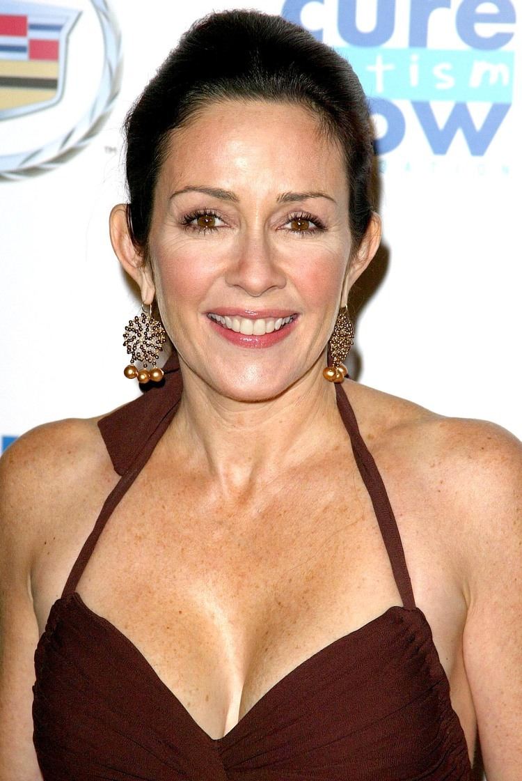 Patricia Heaton wearing earrings, and a sexy maroon dress showing her cleavage.