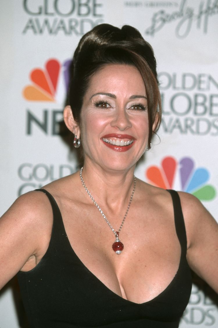 Patricia Heaton wearing earrings, a necklace, and a sexy black top showing her cleavage.