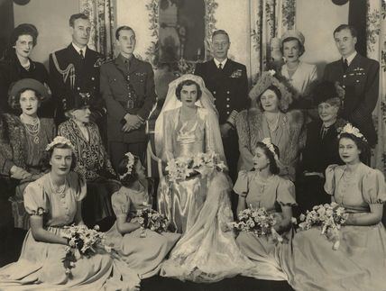 Patricia Knatchbull during her wedding day together with her family. Patricia holding a bouquet of flowers, wearing a gown, and a veil.