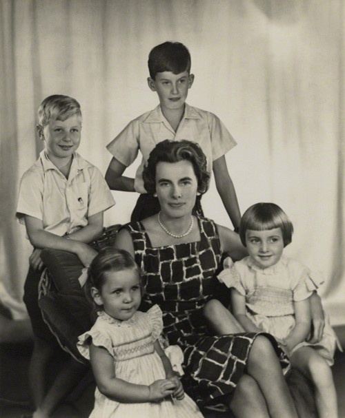 Patricia Knatchbull with a serious face with her four children. Patricia wearing a black sleeveless checkered dress while her sons wearing a white polo shirt and her daughters wearing a white dress.