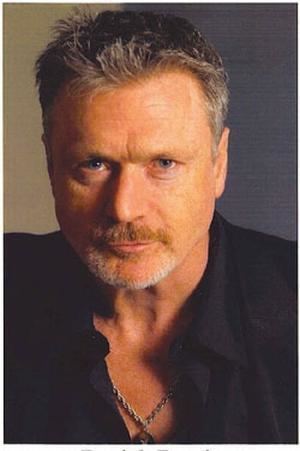 Patrick Bergin wearing black long sleeves and necklace
