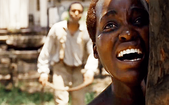 Lupita Nyong'o is crying while Chiwetel Ejiofor is behind her in a scene from the 2013 biographical drama film, 12 Years a Slave