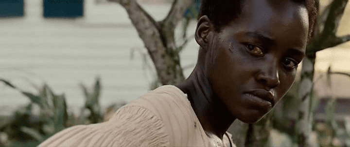 Lupita Nyong'o as Patsey, crying while wearing a beige blouse in the 2013 biographical drama film, 12 Years a Slave