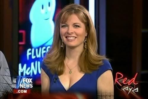 Patti Ann Browne is smiling, with a microphone on her dress, has blonde wavy hair and bangs, wearing silver earrings and a necklace, cleavage showing a blue dress in the Fox News.