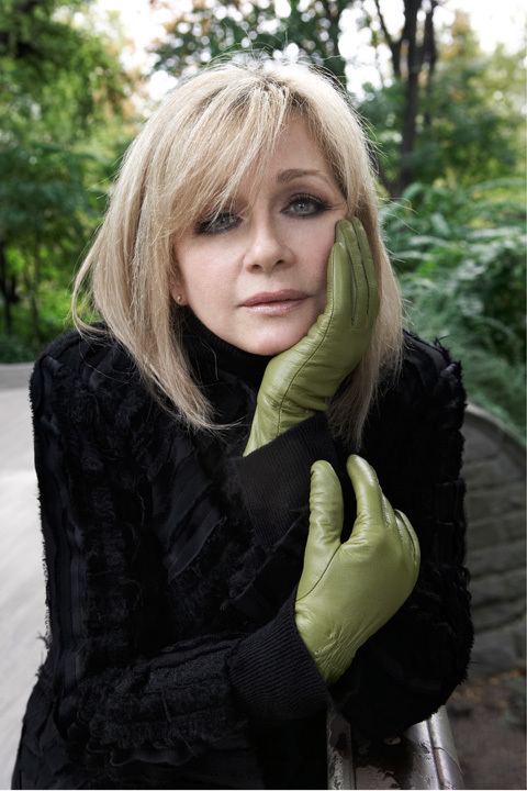 Patti D'Arbanville wearing green gloves and black long sleeves dress