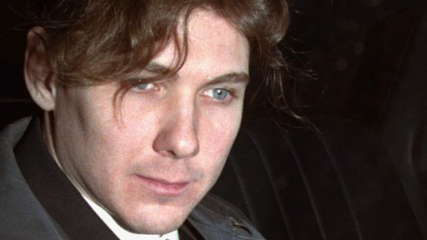 Paul Bernardo wearing a white shirt and a coat