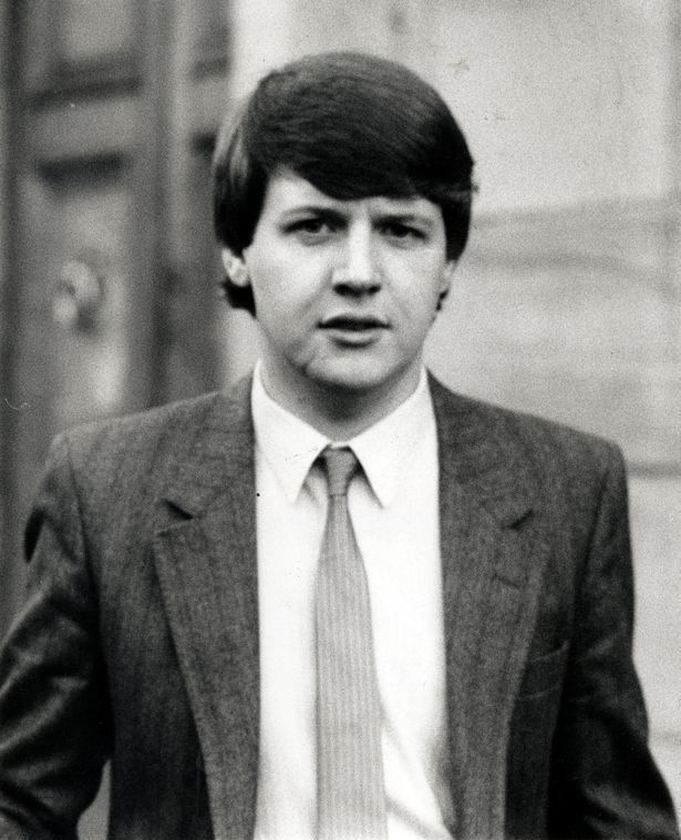Young Paul Ferris wearing a coat, long sleeves, and necktie