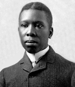 Paul Laurence Dunbar, a seminal African American poet, circa 1890, with a serious face while wearing a long sleeve under a coat