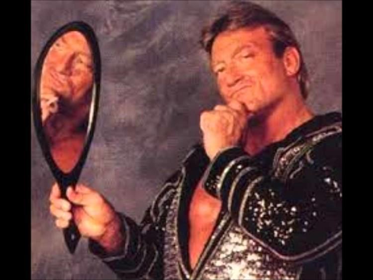 Paul Orndorff holding a mirror while wearing black jacket