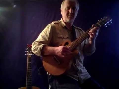 Paul Reynolds playing guitar while wearing a brown long sleeves