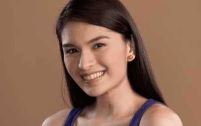 Pauleen Luna with a smiling face, wearing earrings and a blue top.