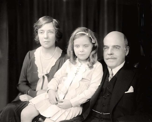 Paulina Longworth, at a young age with her mother Alice Roosevelt wearing a dress and her father Nicholas Longworth wearing a suit.