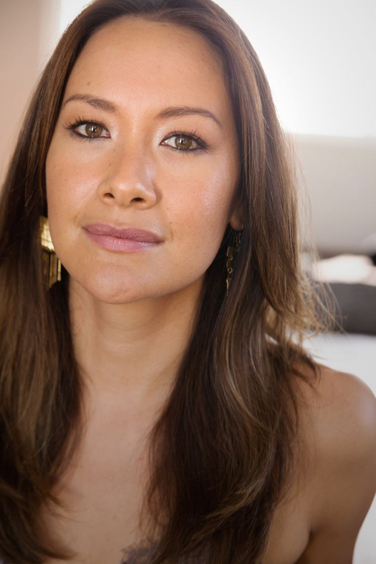 Peta Sergeant with a tight-lipped smile while wearing a gold earrings