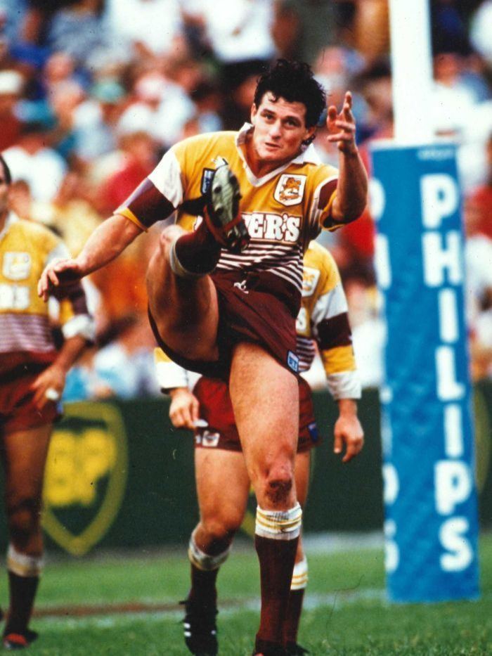 Peter Jackson playing rugby while wearing a maroon and yellow jersey